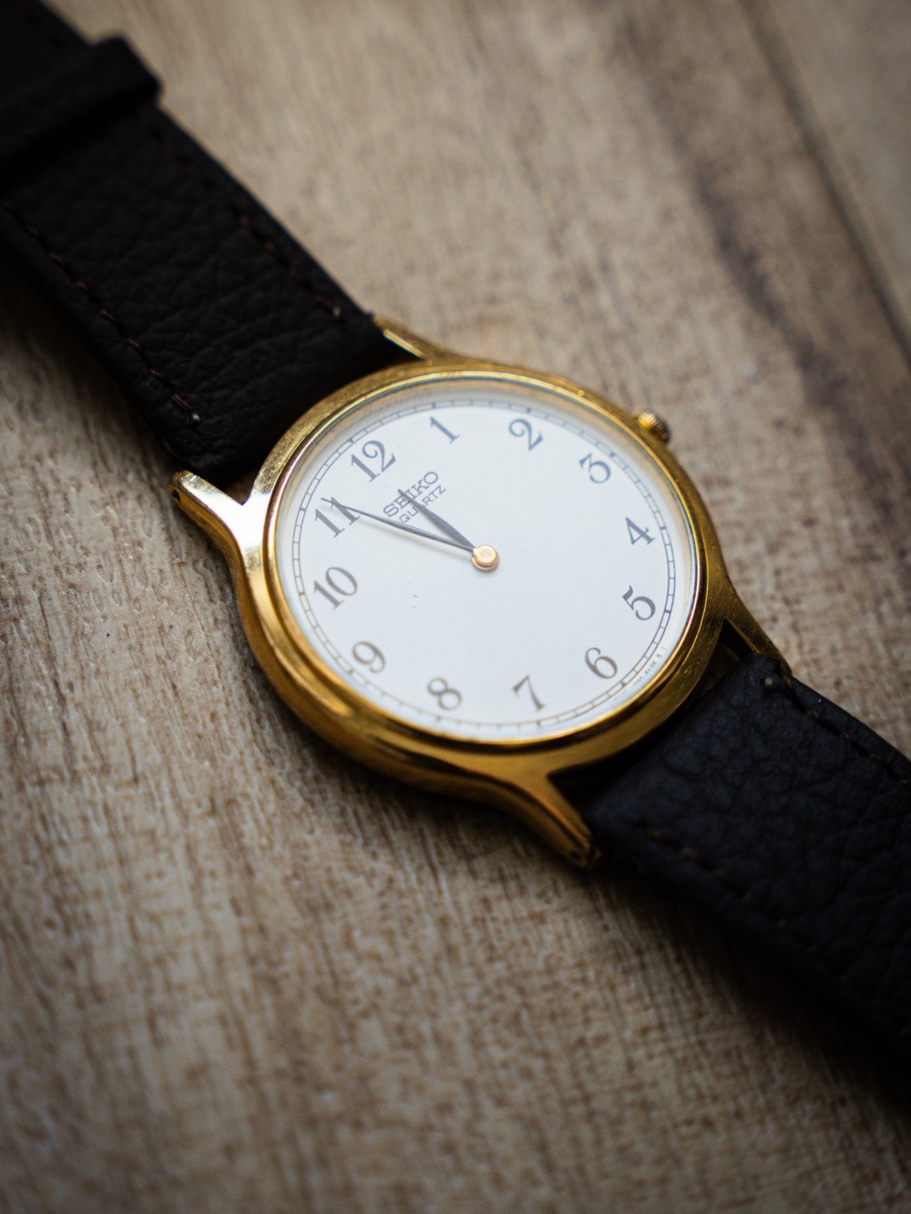 Seiko Gold-Tone Case Watch with White Dial and Black Strap